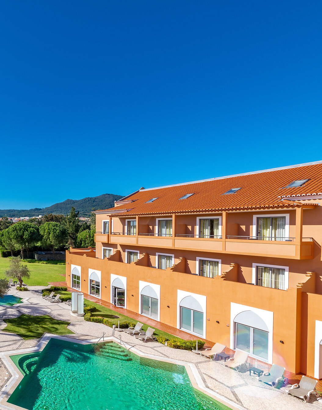 Vista do Pestana Sintra Golf, Hotel 4 Estrelas em Sintra, com piscina exterior, jardim com árvores e um campo de golfe
