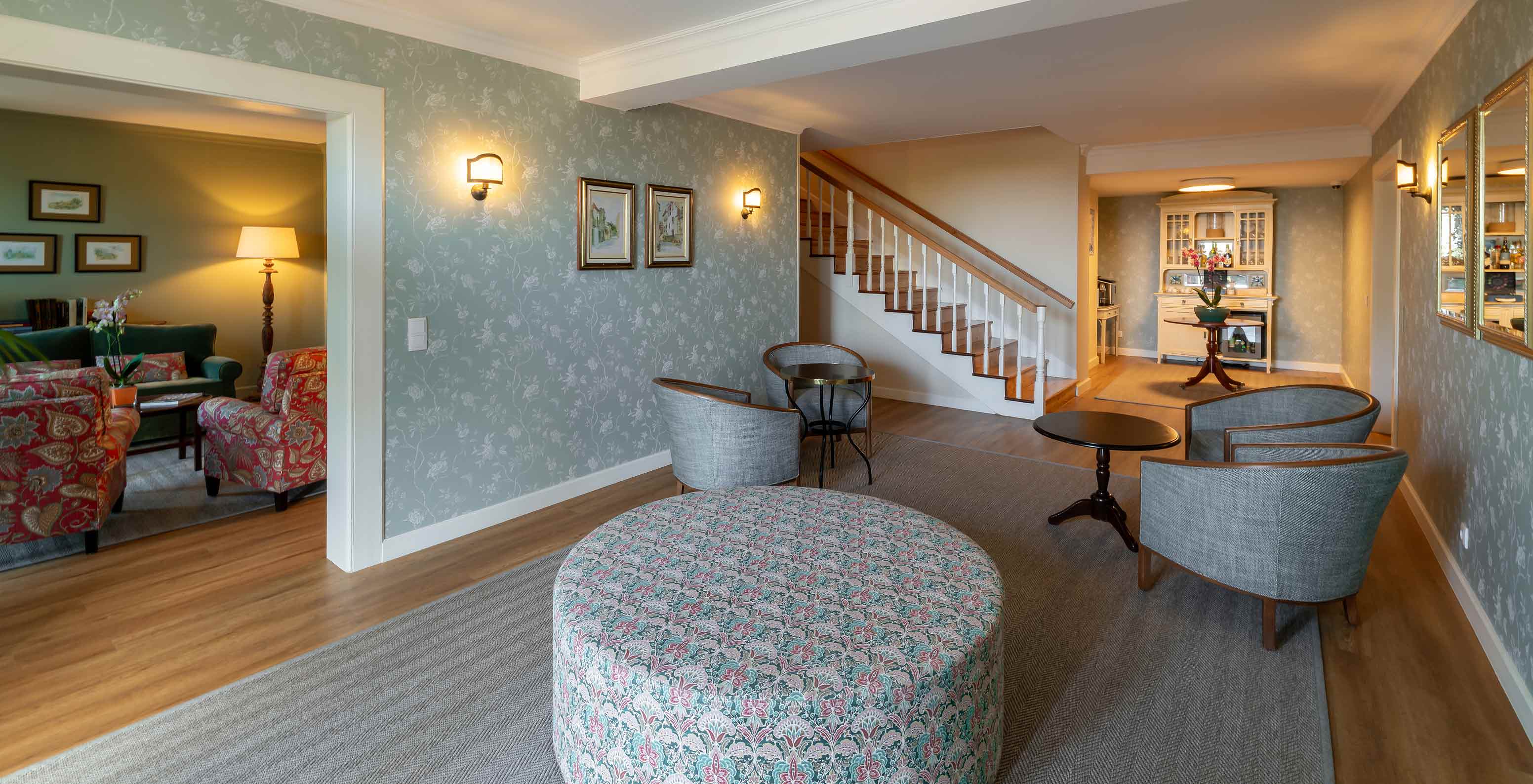 Sala de estar do Pestana Quinta Perestrello com papel de parede, sofás, poltronas e zona de café 