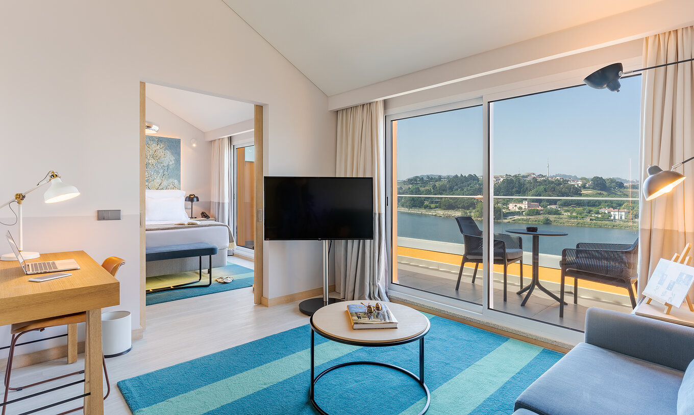 A Suite do Pestana Douro Riverside conta com televisão, secretária e varanda com mesas e cadeiras com vista para o rio Douro