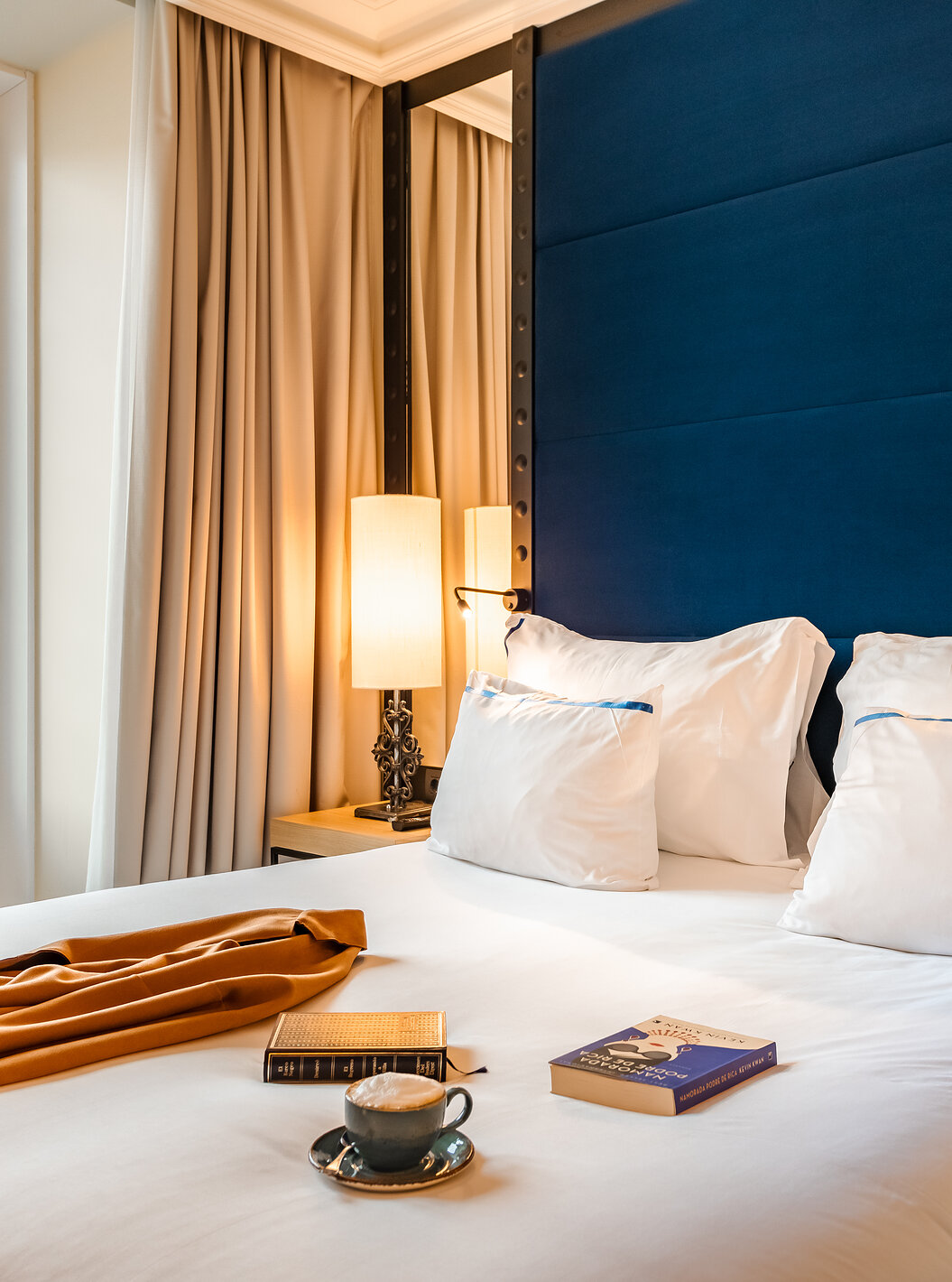 O Superior Plaza Mayor do Pestana Plaza Mayor Madrid tem uma cama de casal com cabeceira azul com espelho e uma janela grande