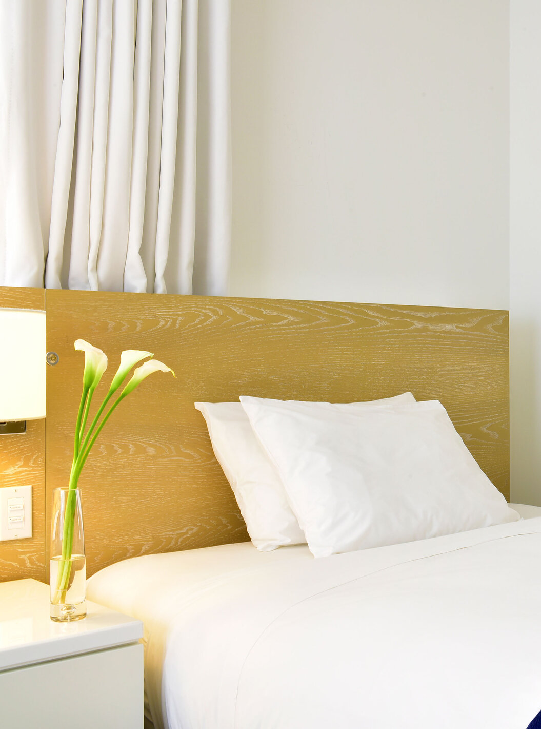 O Superior Duplo com Camas Queen do Pestana Miami South Beach é um quarto moderno com cama branca e decoração minimalista.