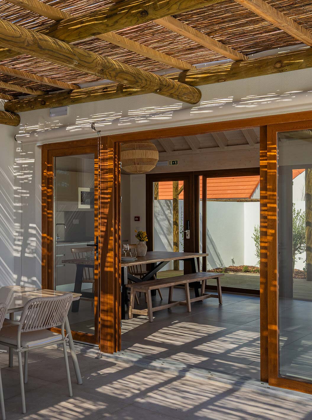 A Premium Green Villa do Pestana Comporta Village Residences tem um pátio coberto com uma mesa que dá acesso ao interior