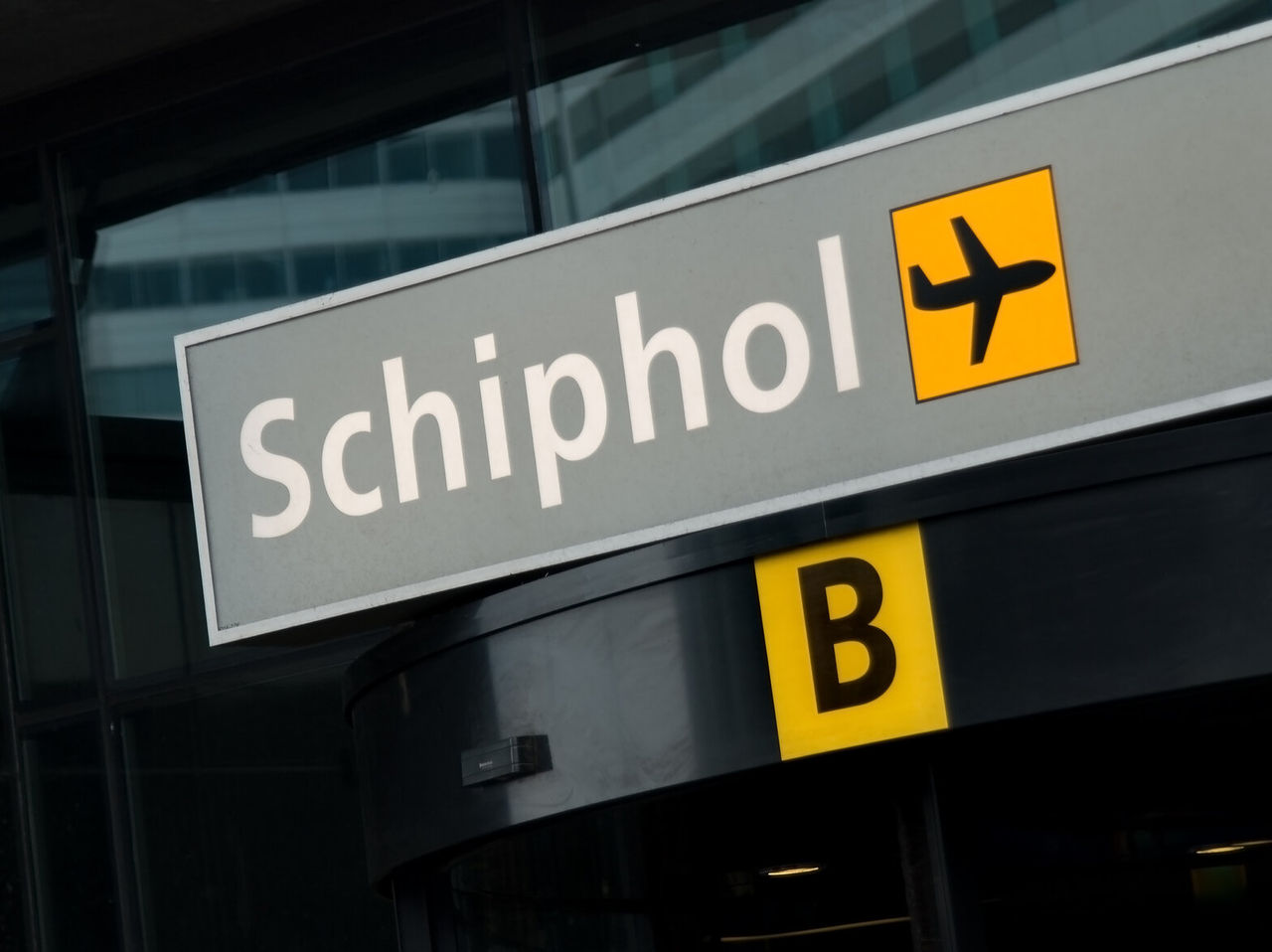 Grijs bord met witte letters met Terminal B op Schiphol Airport in Amsterdam, Nederland