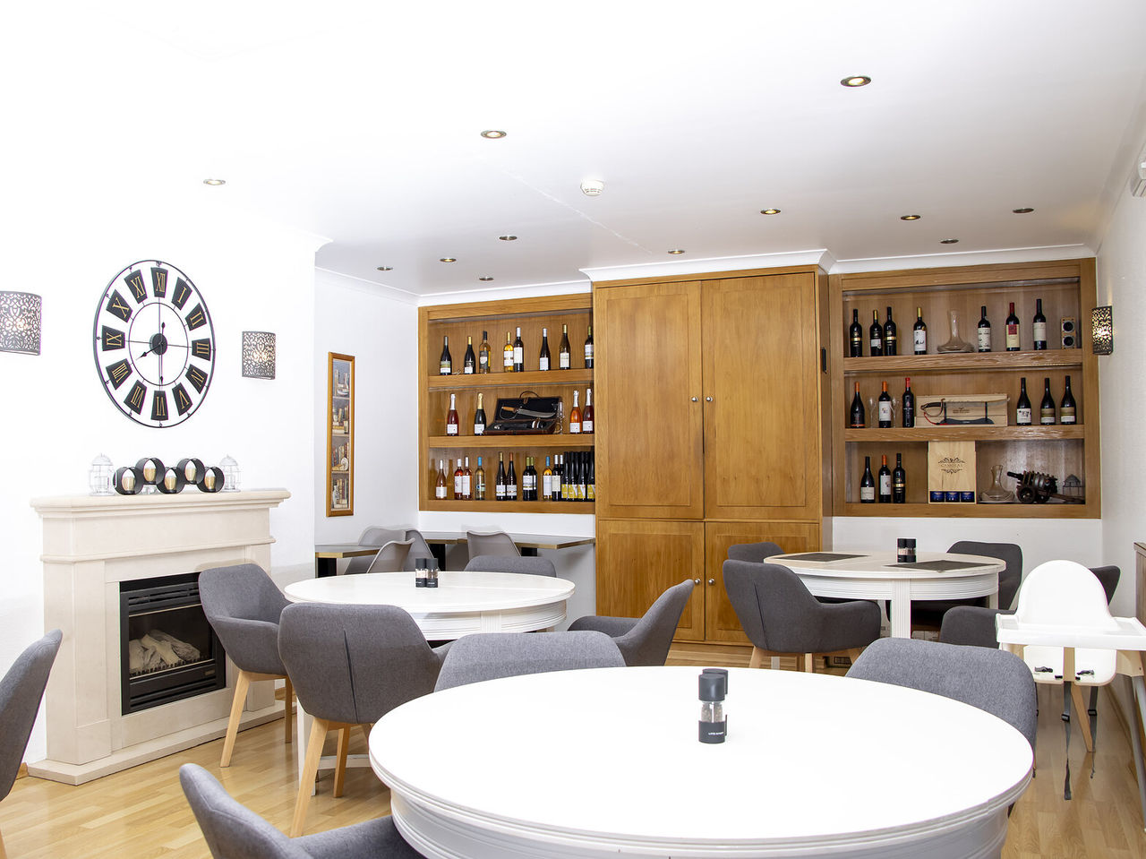 Het restaurant Sal & Tal, van het 4-sterrenhotel in Carvoeiro, Algarve, heeft ronde tafels en een kast met diverse wijnen