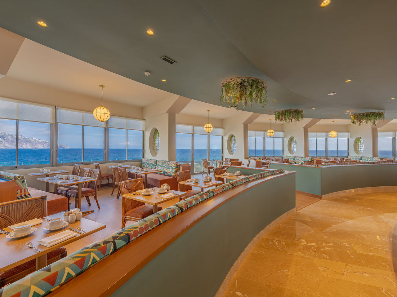 Het restaurant Flor do Mar, van het Hotel met Toegang tot de Zee in Funchal, heeft tafels met sofa's en uitzicht op zee