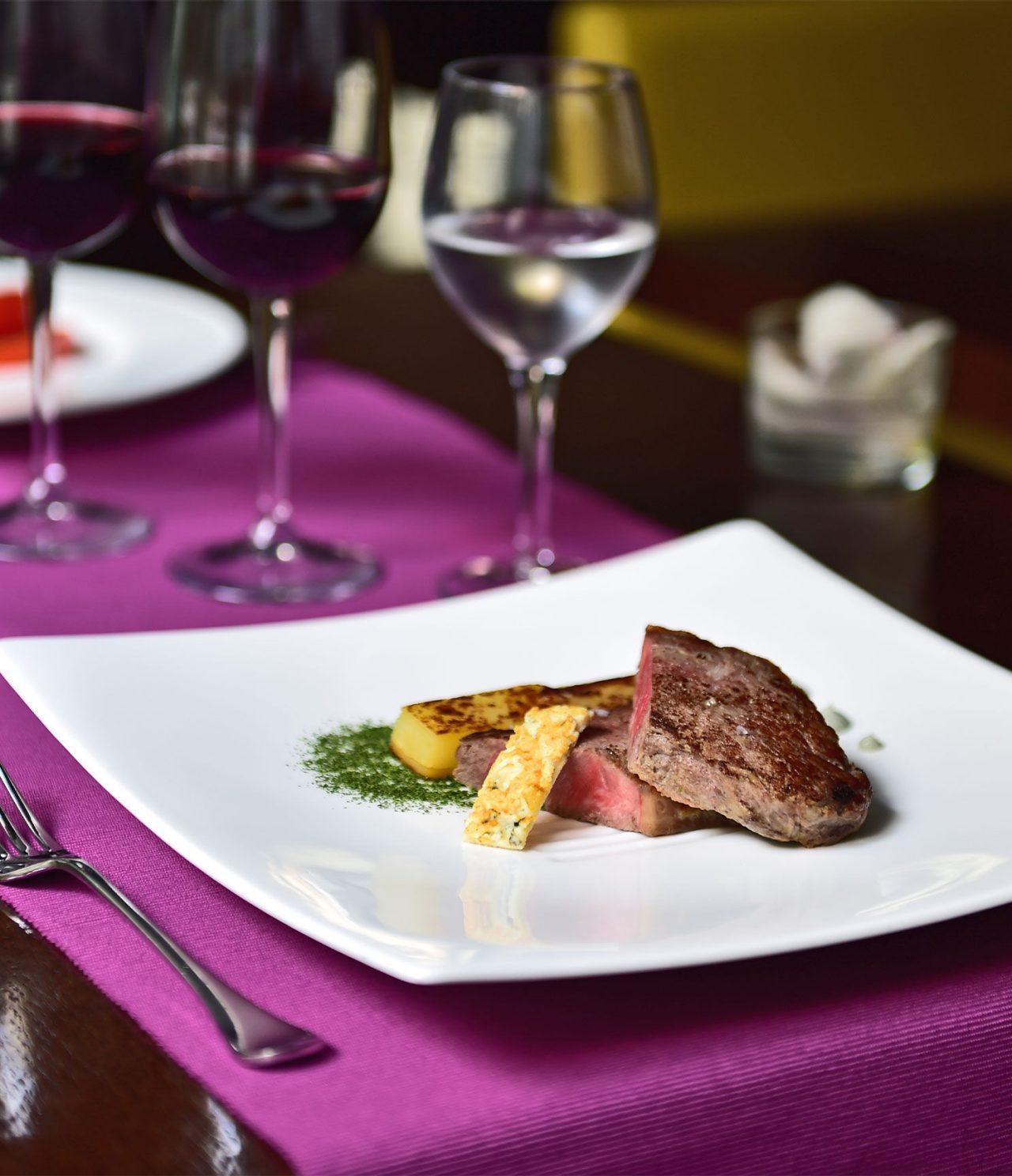 De bar Lobby, van het Hotel in Barcelona, heeft een elegant gerecht met vlees en fruit, en een glas wijn
