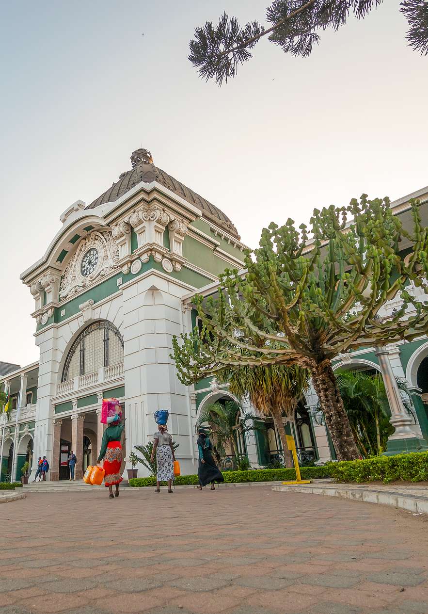 People arriving at Maputo station a historic landmark of the city with classic architecture and ornamental details