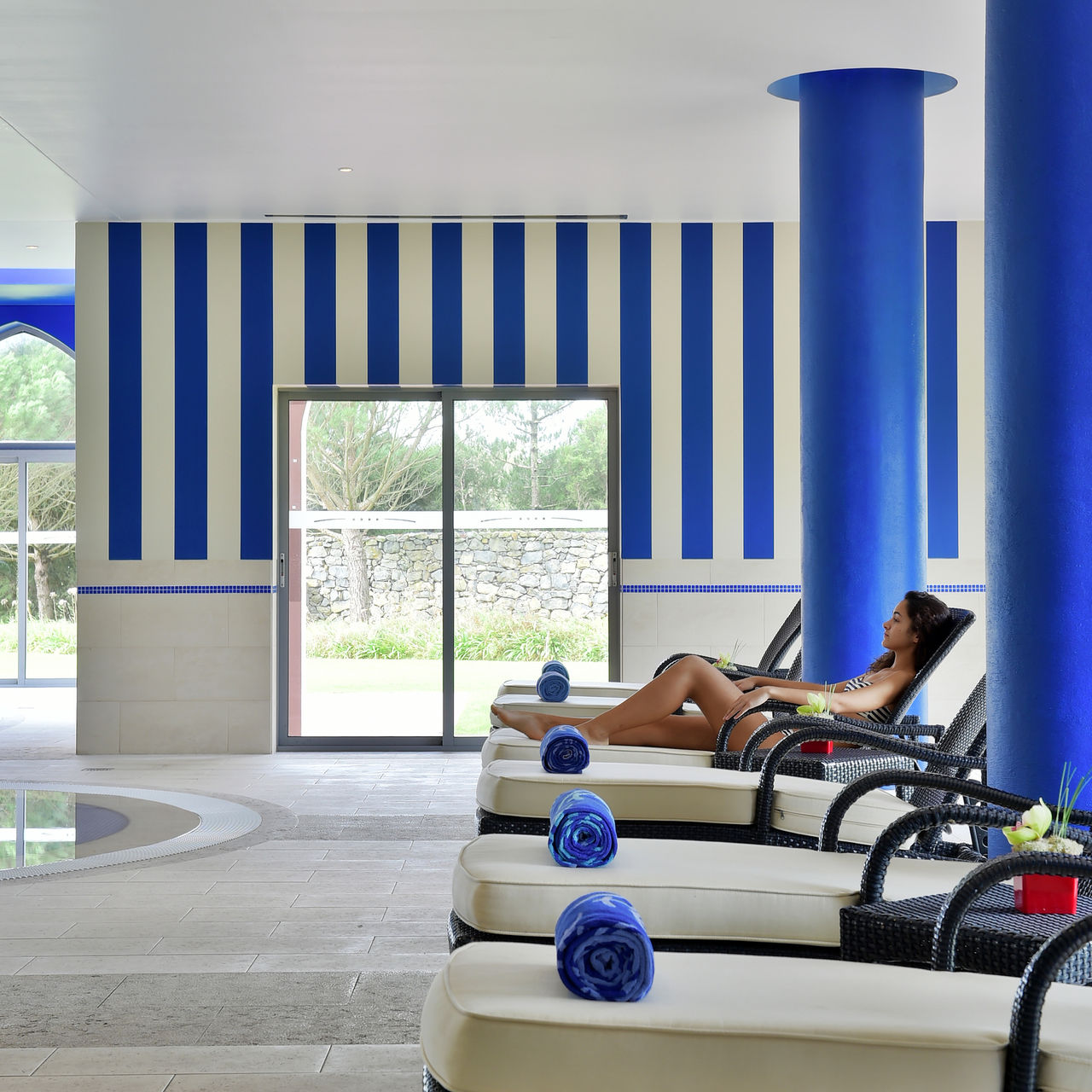 Indoor pool at Pestana Sintra Golf, a 4-star hotel in Sintra, with cushioned loungers and blue towels