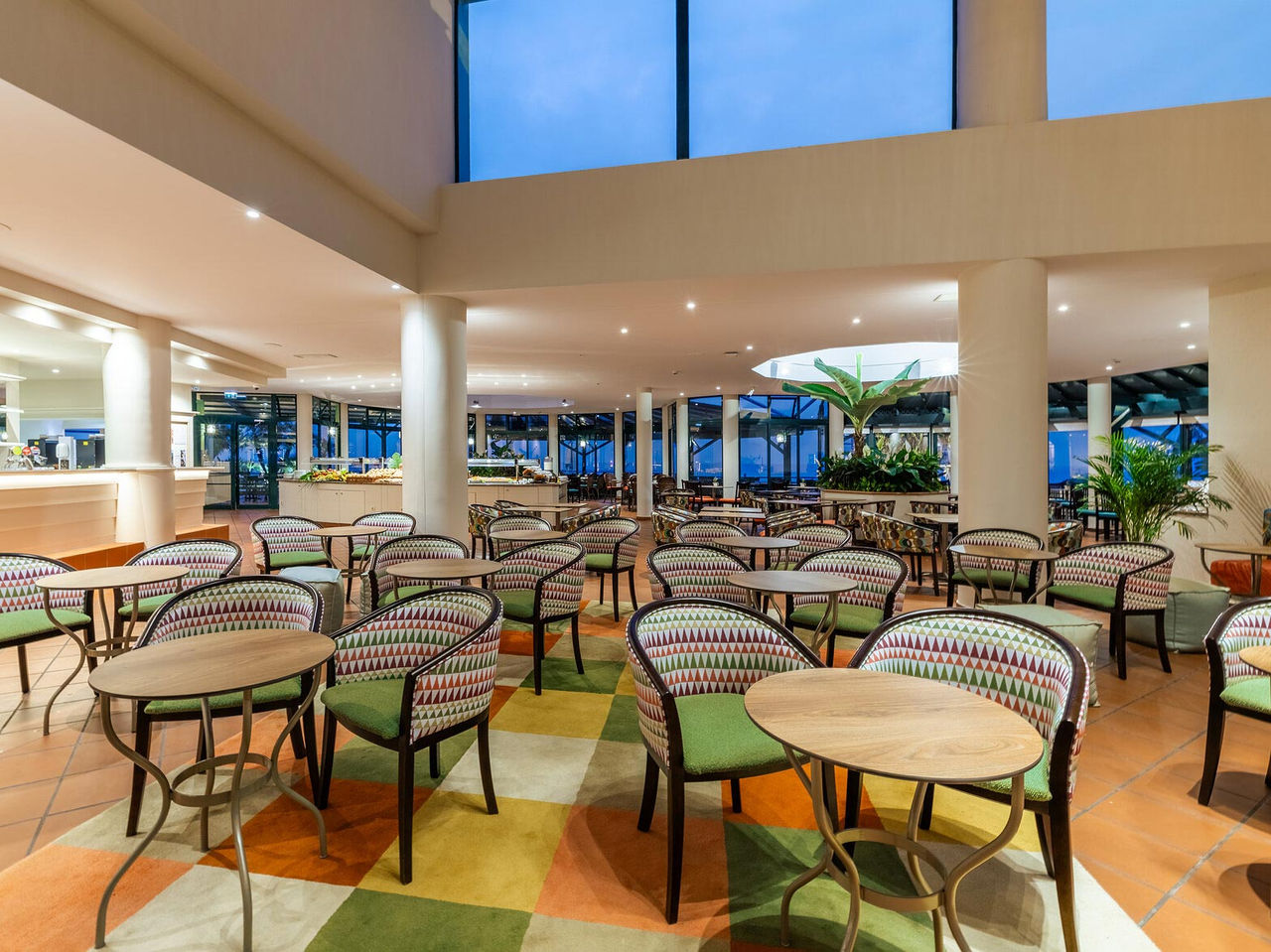 The Arlequim bar at the 5-star hotel in Funchal, Madeira has chairs with round tables and checkered carpet