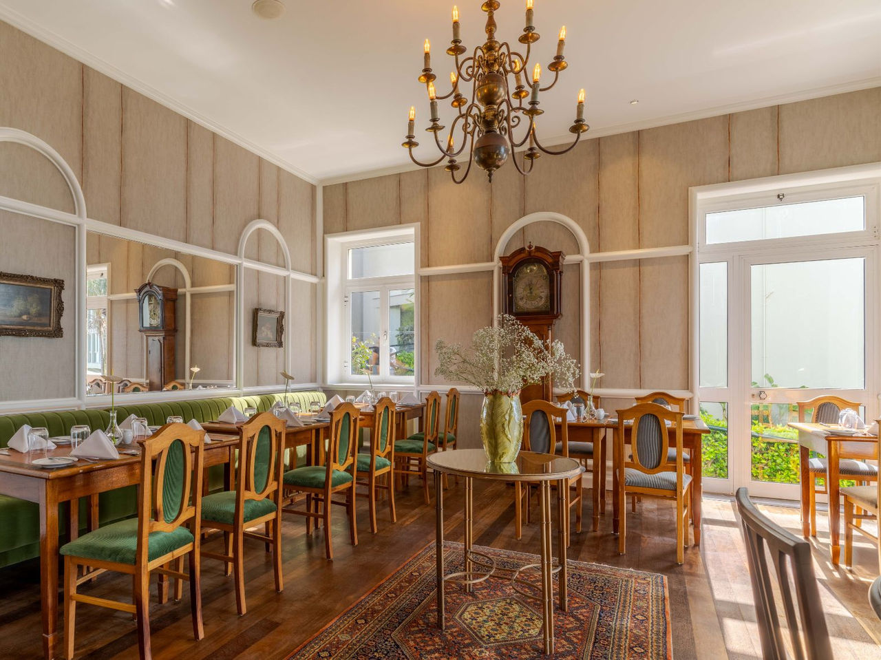 The Vila Lido Restaurant, at the Hotel with Sea Access in Funchal, has striped wallpaper, windows, and antique chairs