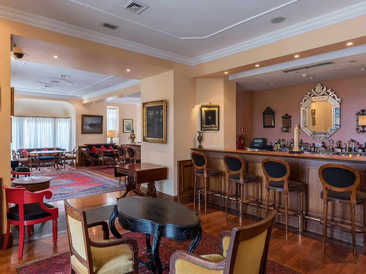 The A Fonte Bar, at the Romantic Hotel in Funchal, Madeira, has a counter with high stools, several tables, and sofas