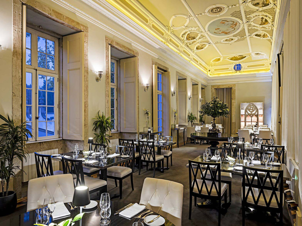 The Palatium bar of the 5-star hotel in Porto, a National Monument, has cushioned chairs and a painted ceiling