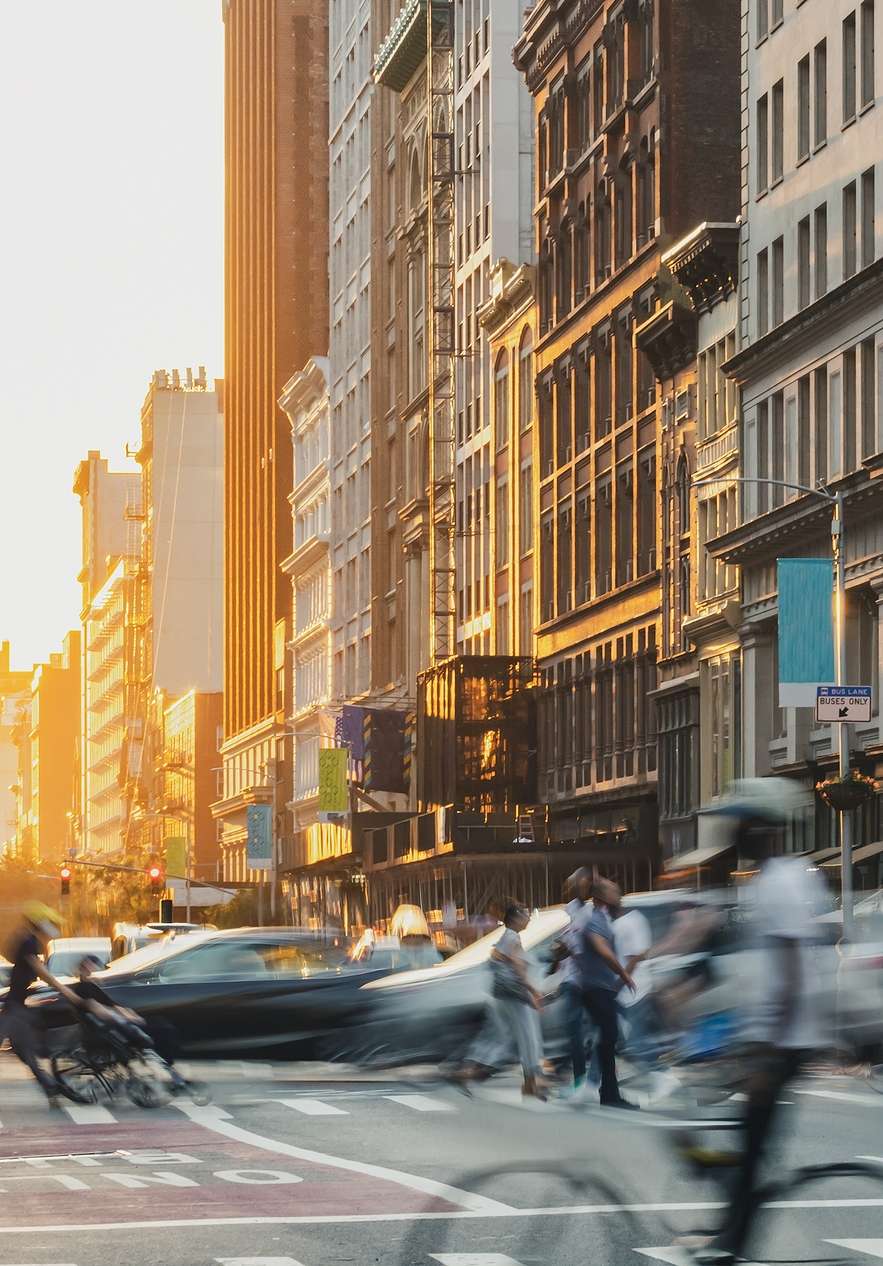 View of Fifth Avenue in Manhattan New York with skyscrapers cars and people moving