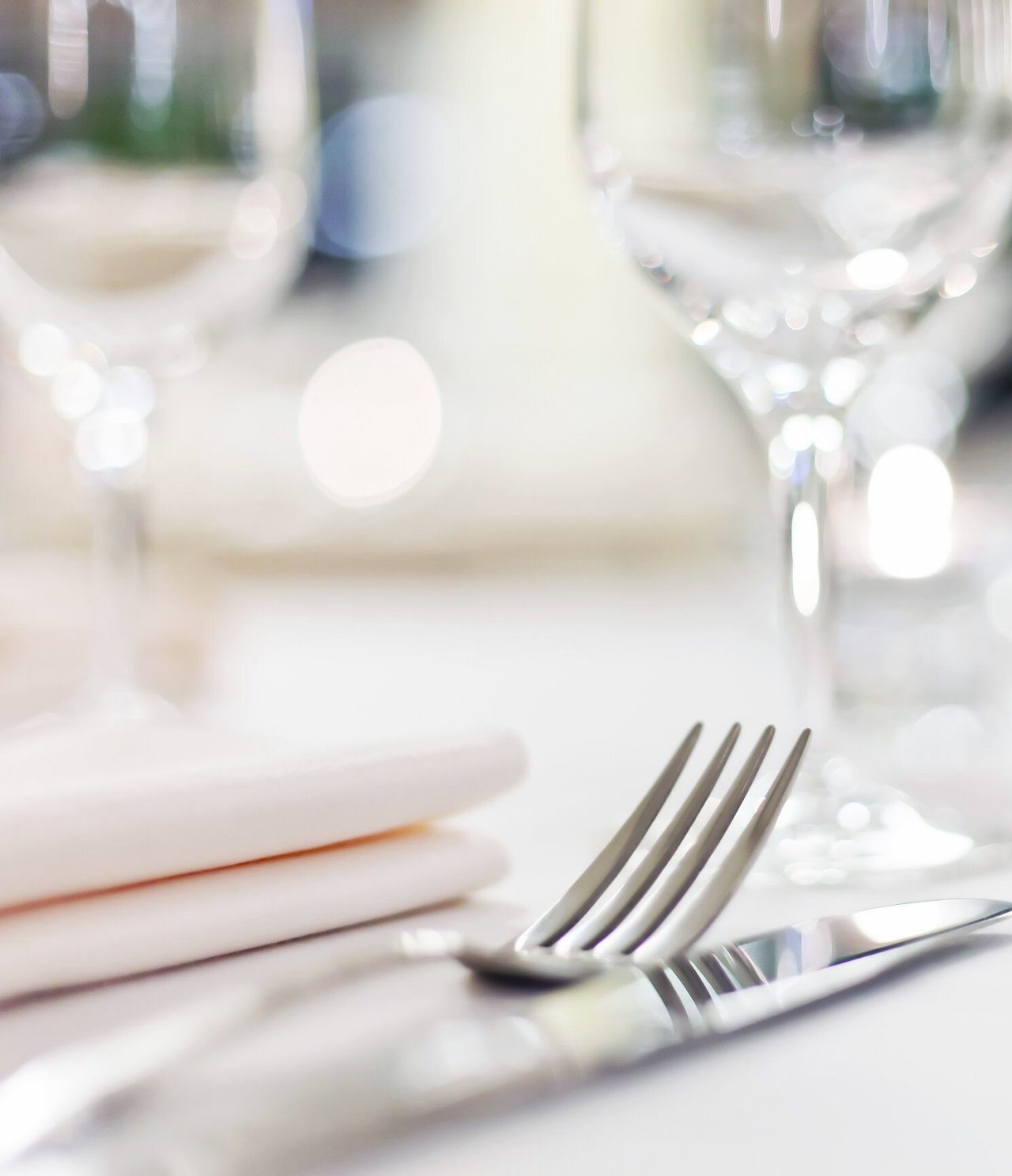 Elegantly set table with silver cutlery, cloth napkin, and glass cups, to sample São Paulo's cuisine