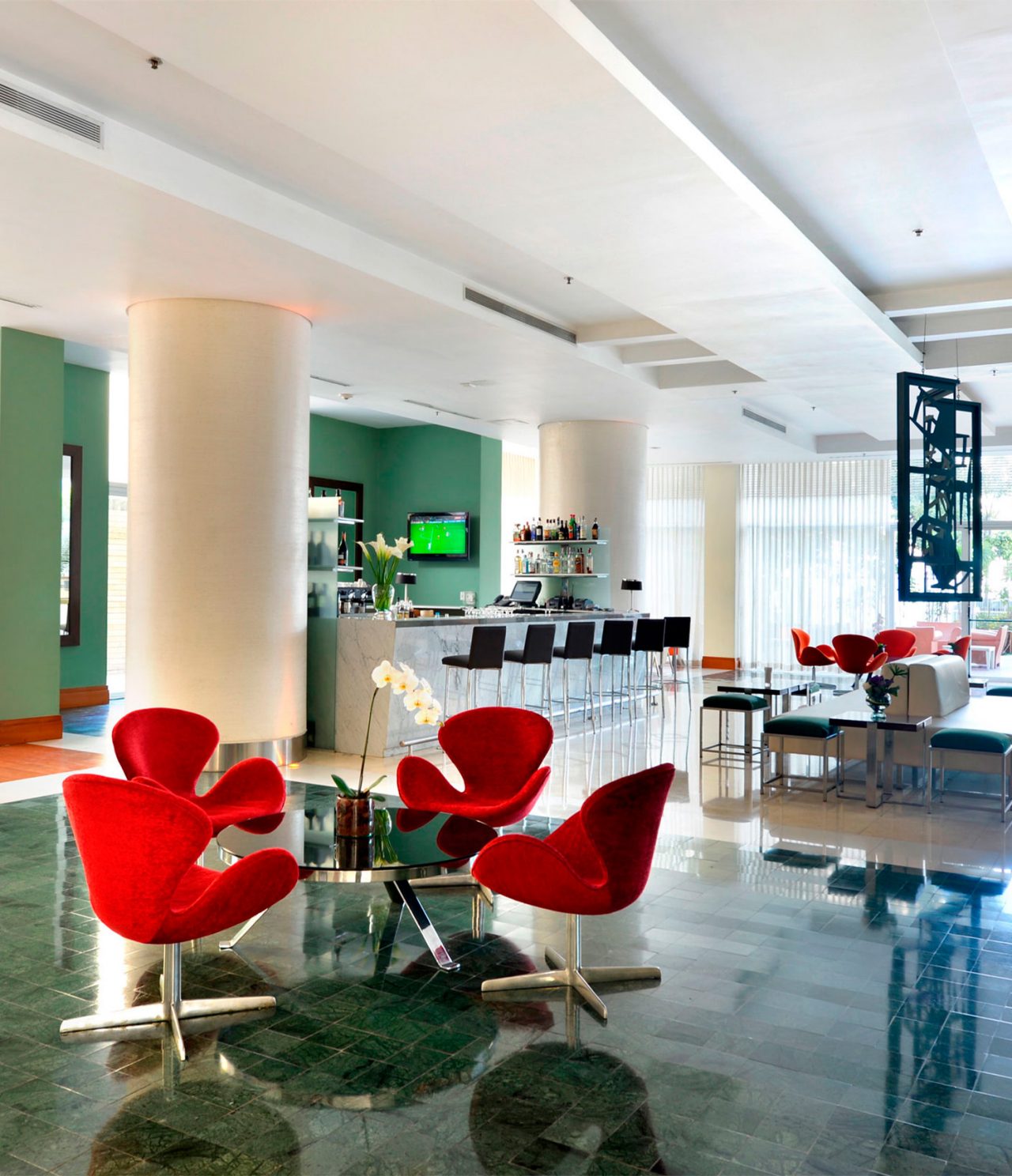 Lobby Bar offers natural light, a TV, and tables for a comfortable experience